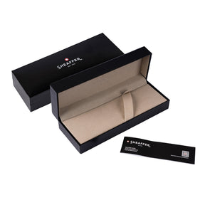 The Sheaffer® 100 9370 Glossy Coffee Brown Ballpoint Pen With PVD Gold-Tone Trim is a stylish black box containing a watch and a card, making it the perfect gift for those seeking a heightened writing experience.